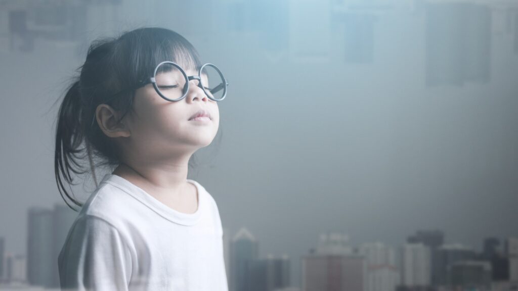 Asian little girl closing eyes and modern cityscape.