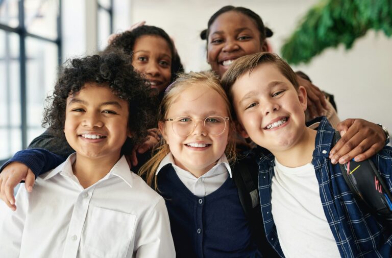 Shot of a diverse group of children standing together in the hallway at school during the day